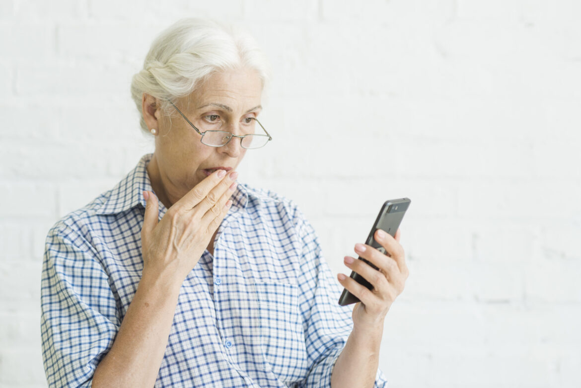 shocked-aged-woman-looking-mobile-against-backdrop-scaled royal holiday scam