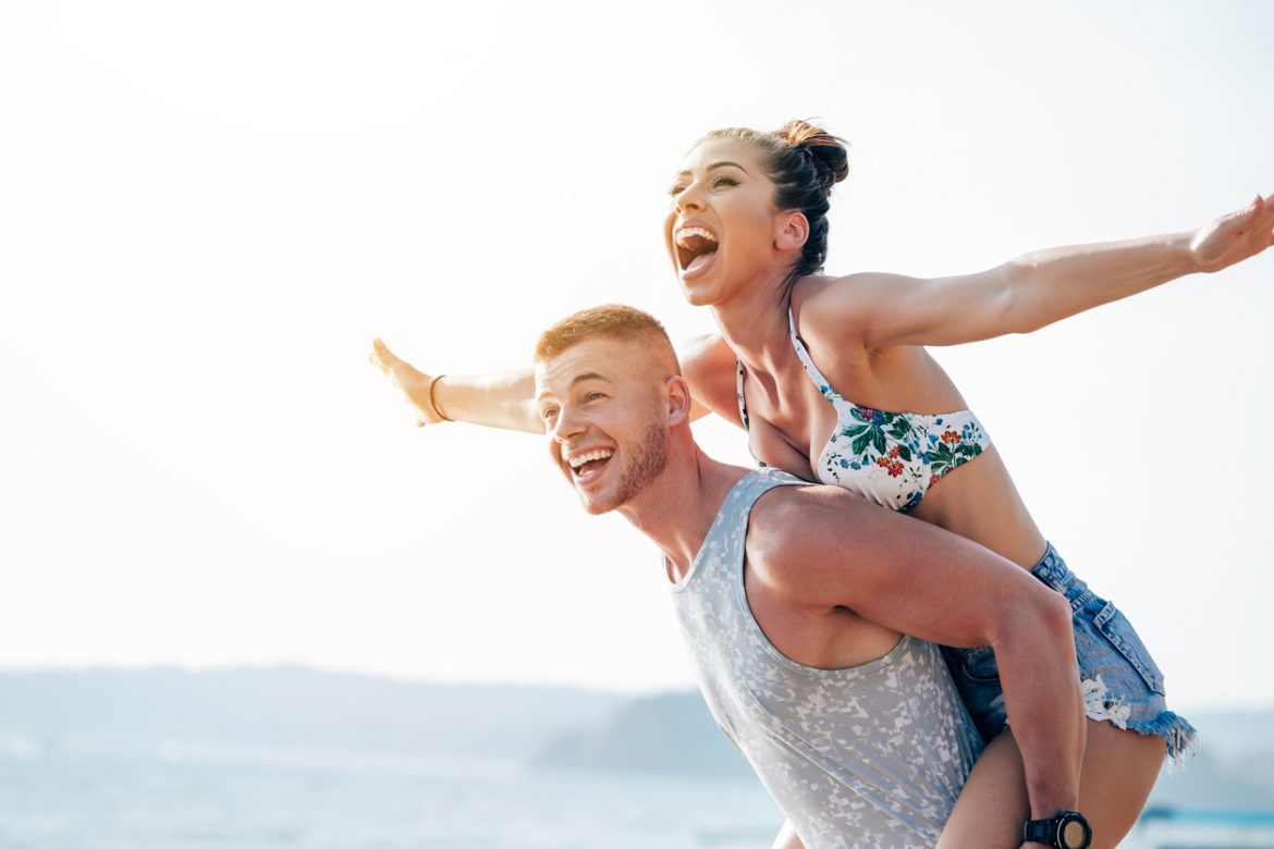 Cheerful boyfriend carrying girlfriend on his back