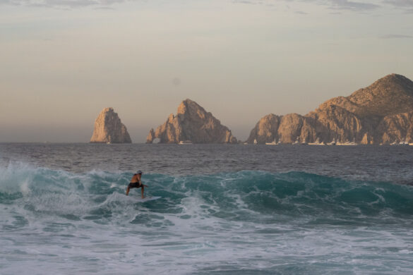 Surfer in front of the arch of cabo san lucas
